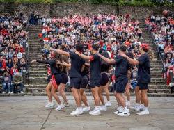 Dancers perform in front of a crowd in an outdoor amphitheater.